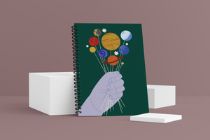 Give You the Galaxy Wellness Journal. Cover shows a blue hand holding planets like lollipops 